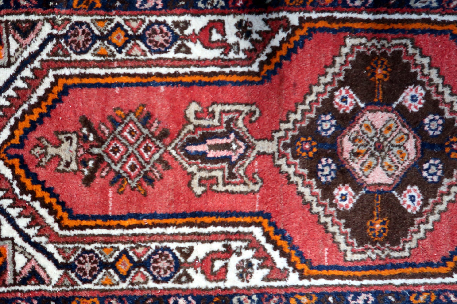 Close-up view capturing the vibrant orange hues and geometric patterns on the rug