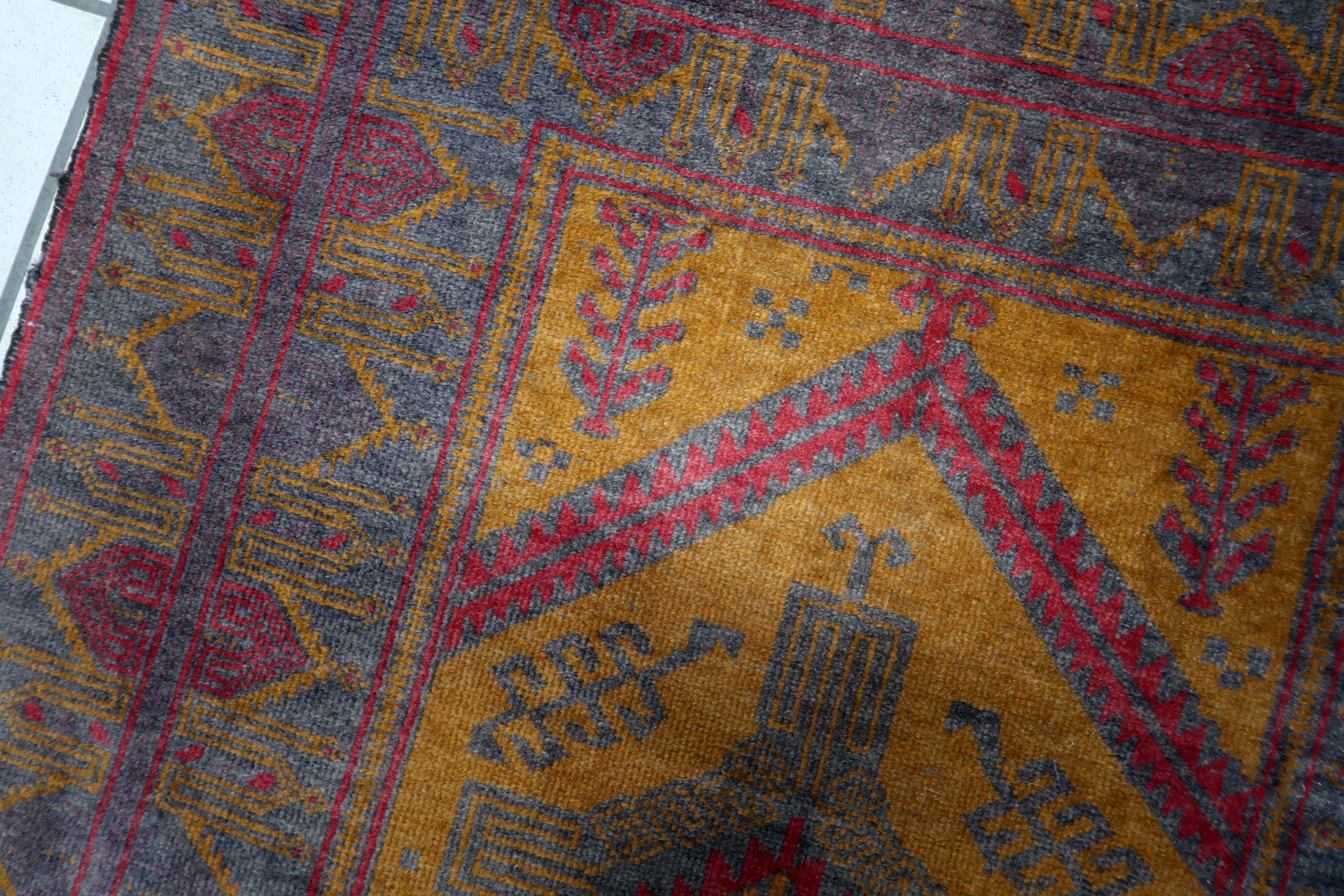 Close-up of the vibrant fuchsia color on the Afghan Baluch rug