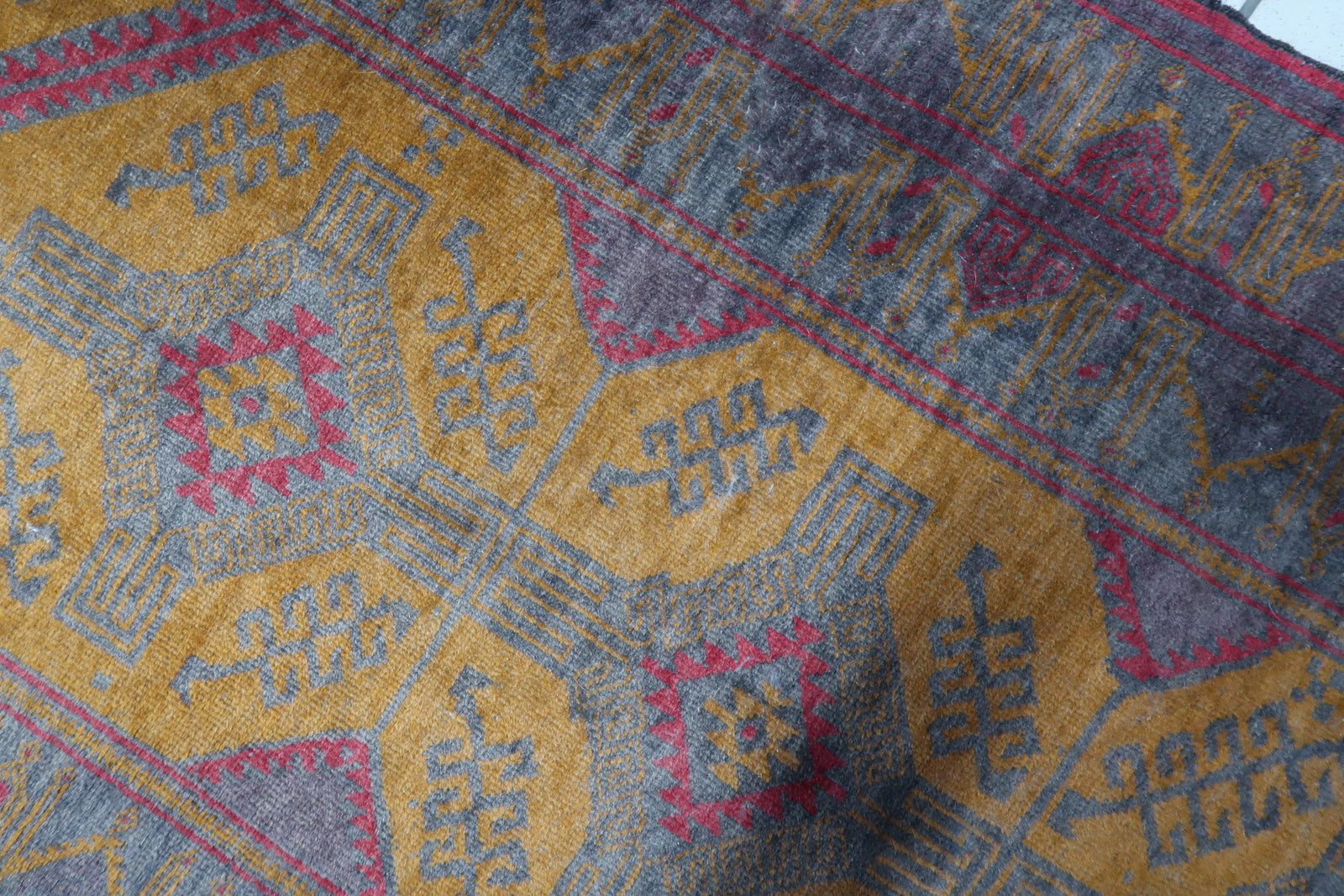 Detailed view of the orange accents and motifs on the Afghan Baluch rug