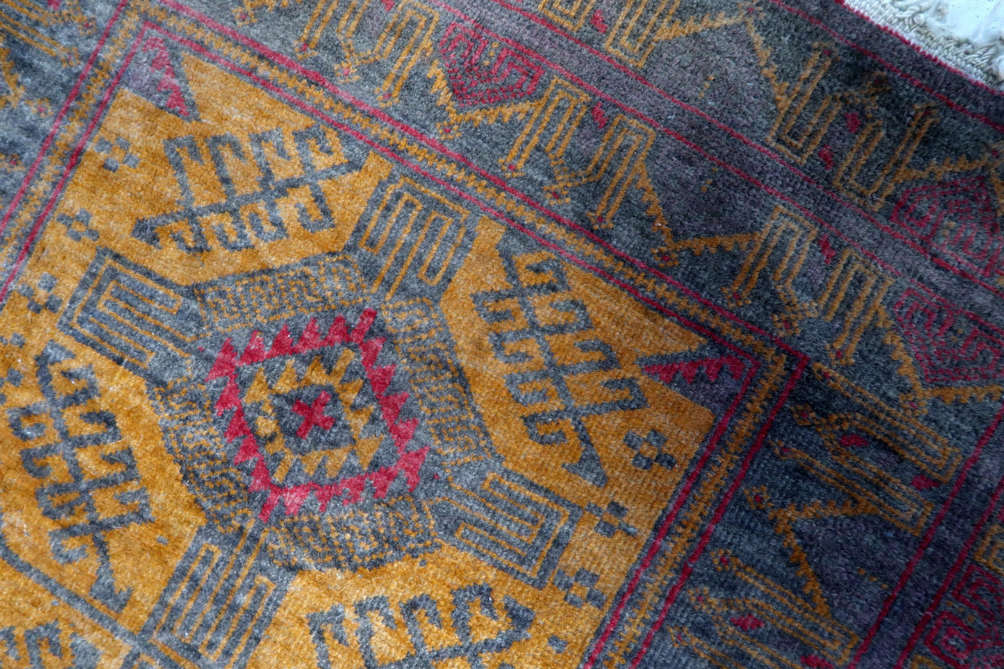Greyish purple background color highlighting the design elements on the Afghan Baluch rug