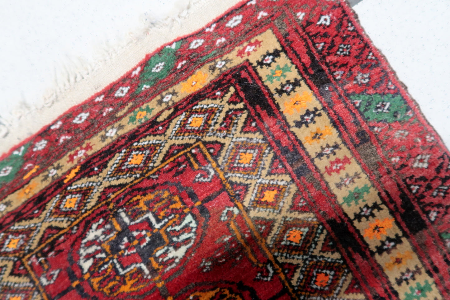 Close-up of intricate patterns and vibrant colors on the vintage Afghan Ersari mat