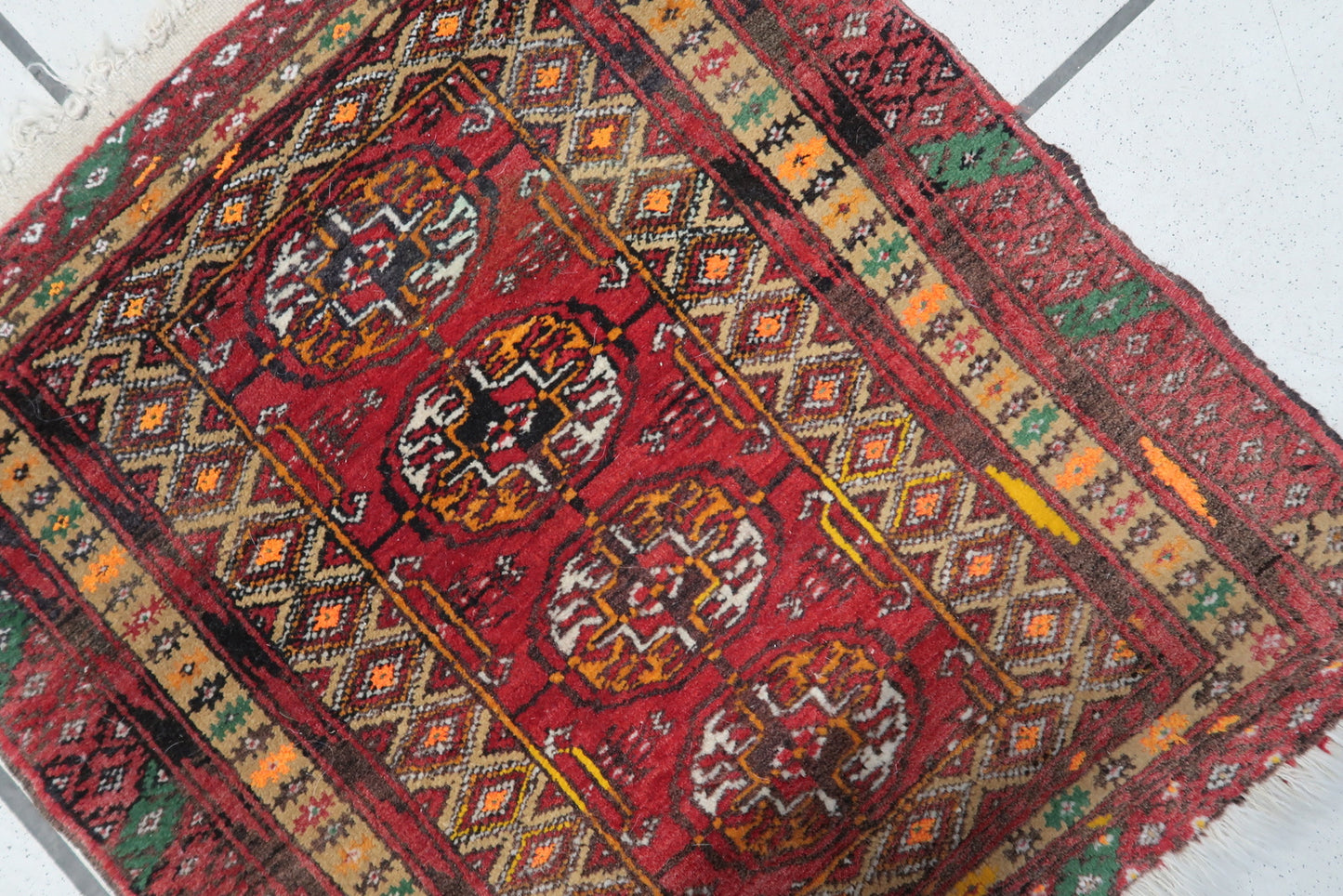 Detailed view of the red background color on the vintage Afghan Ersari mat
