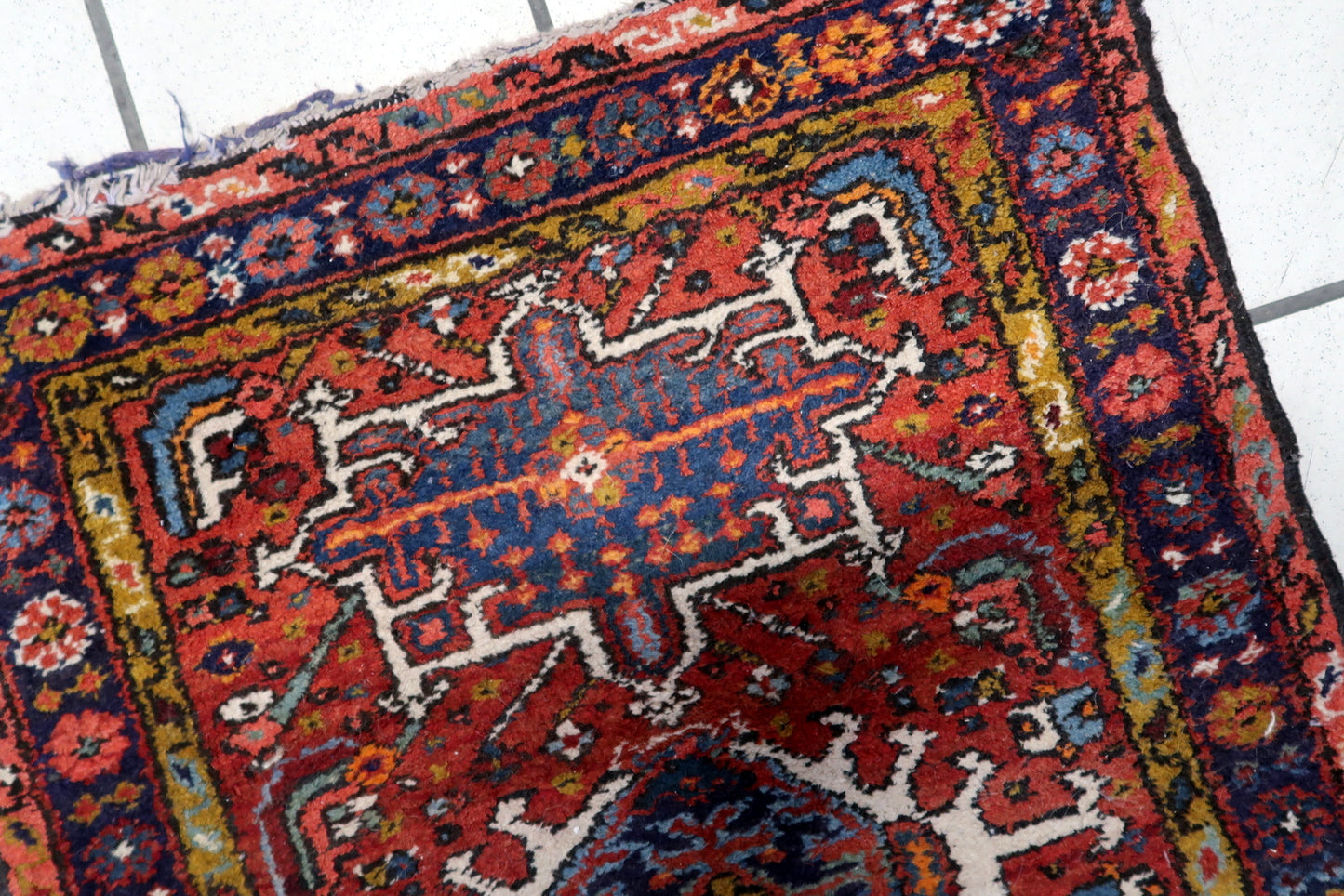 Close-up of the intricate geometric patterns on the Handmade Antique Persian Karajeh Rug