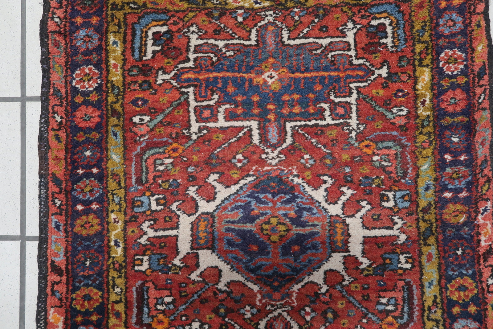 Detailed view of the rich red color and floral motifs on the Handmade Antique Persian Karajeh Rug