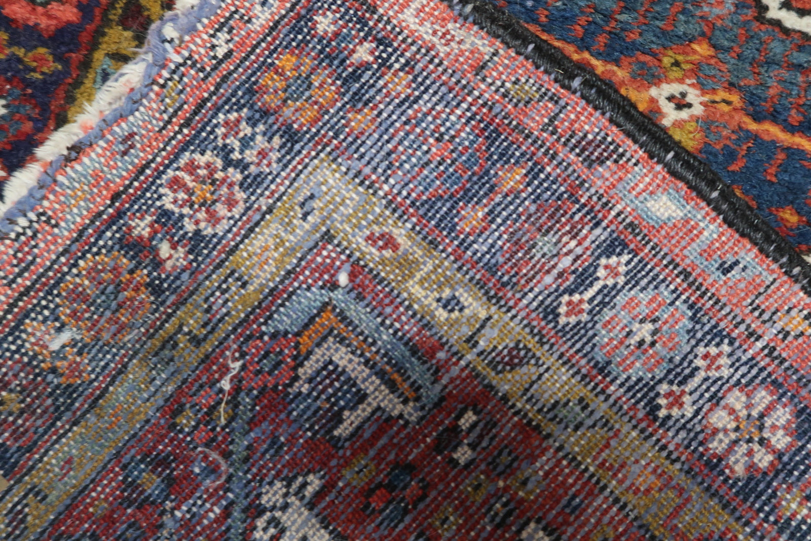 Back side of the Handmade Antique Persian Karajeh Rug, revealing its woven patterns and craftsmanship