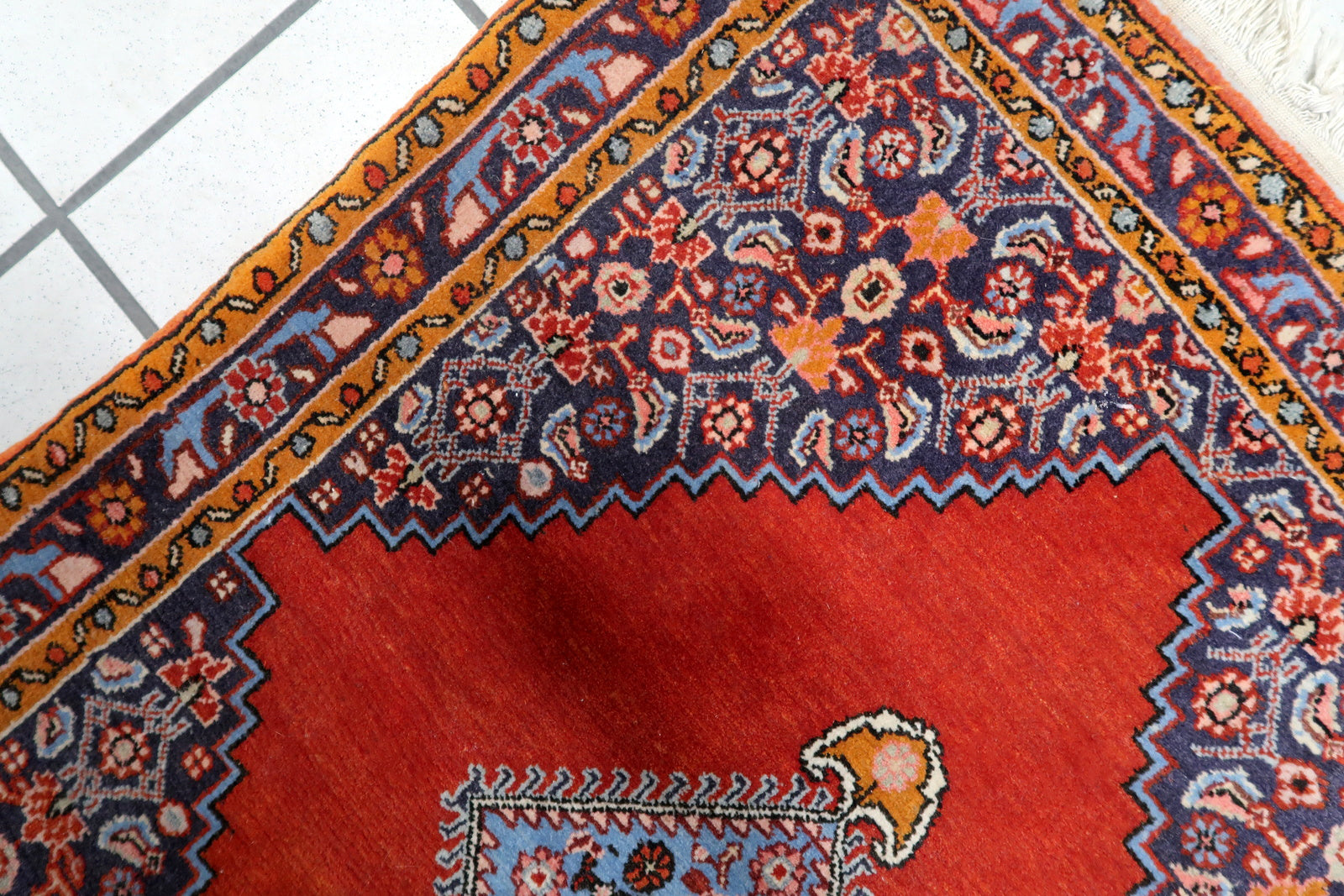 Brick red background with dense, compact wool pile

