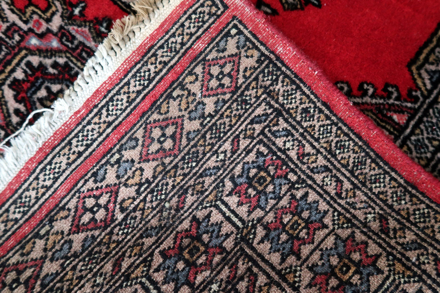 Back side of the Handmade Vintage Uzbek Bukhara Rug, showcasing craftsmanship.