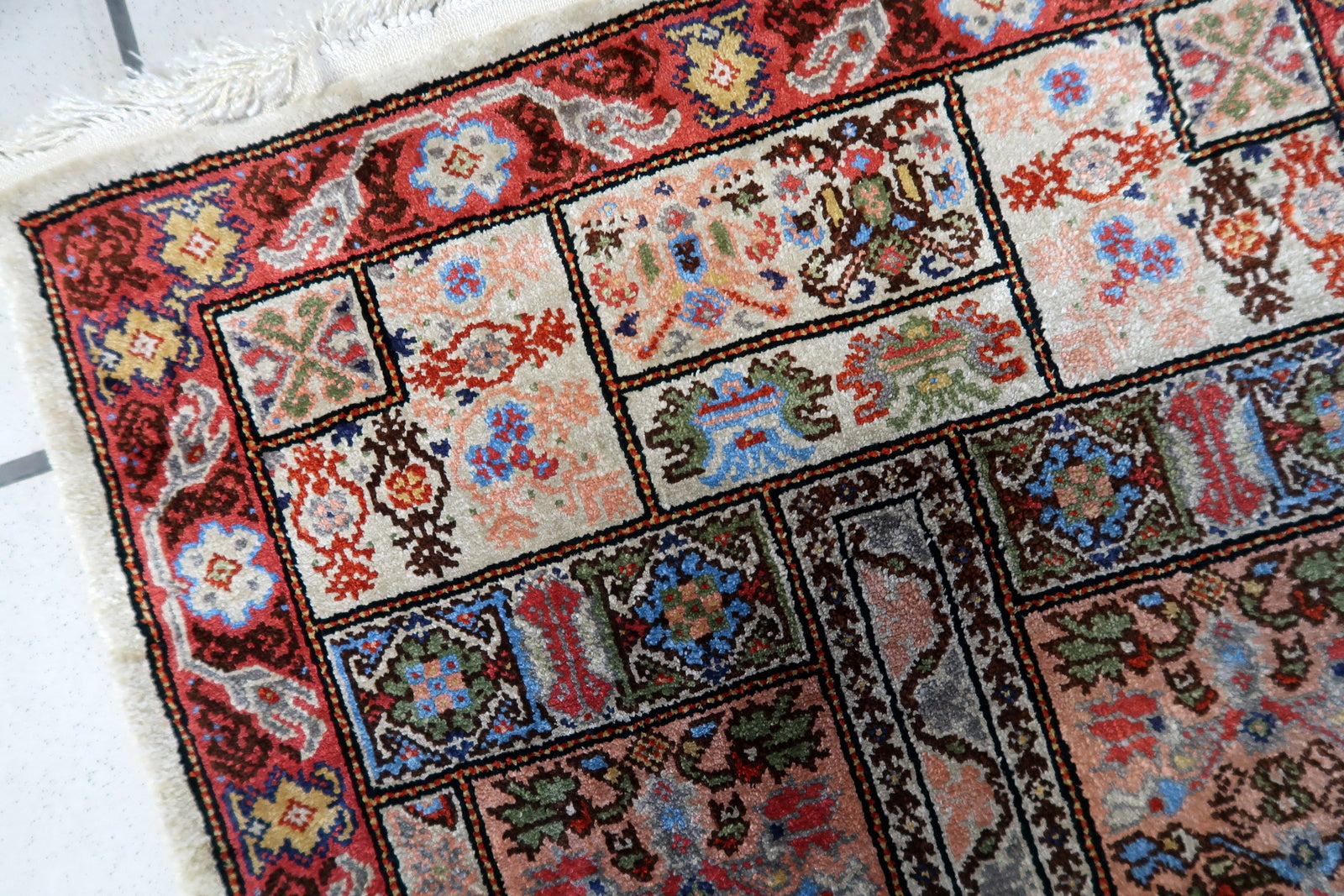Close-up of the intricate floral motifs and geometric shapes on the Tunisian silk rug