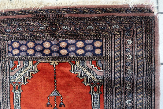 Close-up of the elegant arch-like design and delicate tassel motifs on the rug's surface
