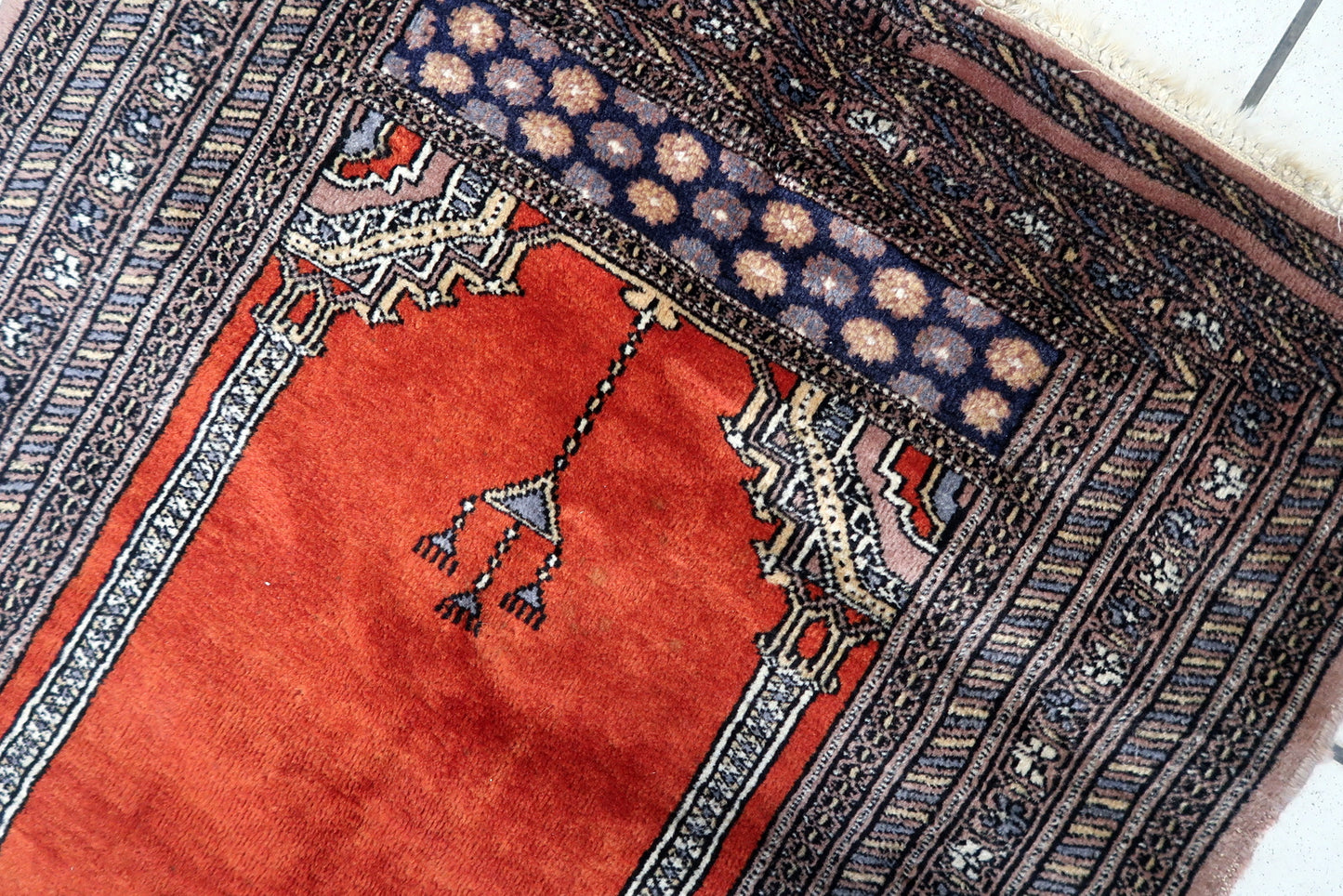 Overhead shot of the Pakistani Lahore prayer rug displaying its warm and inviting ambiance