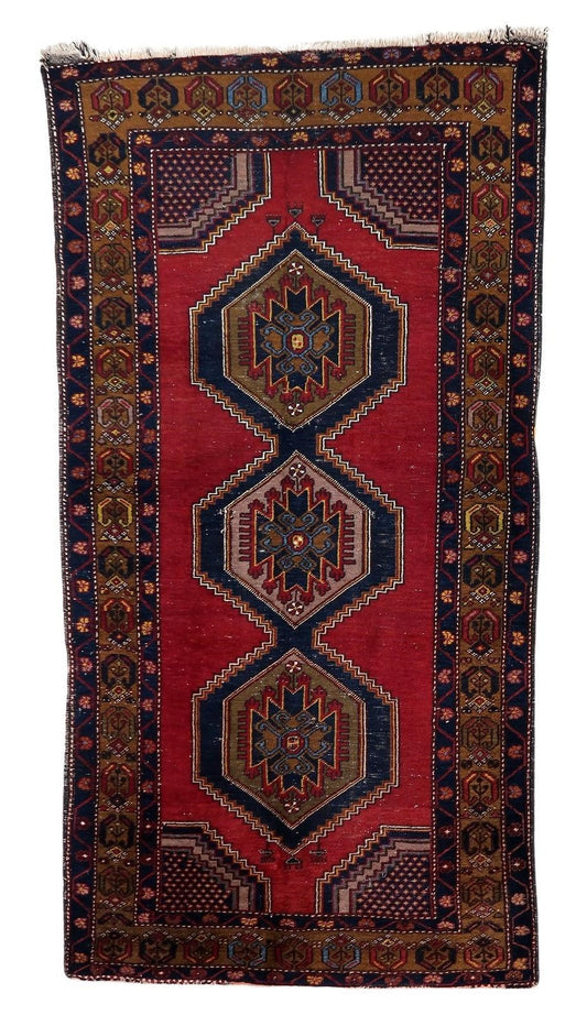 Handmade antique Turkish Anatolian rug showcasing rich tapestry of colors on a deep red background
