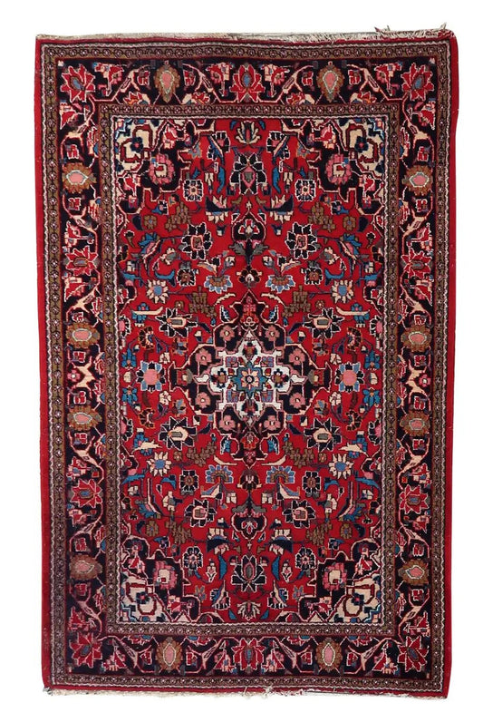 Handmade antique Persian Style Kashan rug showcasing rich tapestry of colors on a deep red background