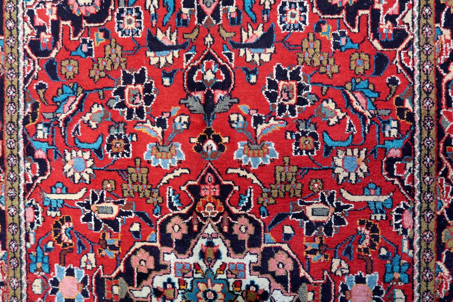 Detailed view of the complex patterns in the border, showcasing the harmonious blend of colors
