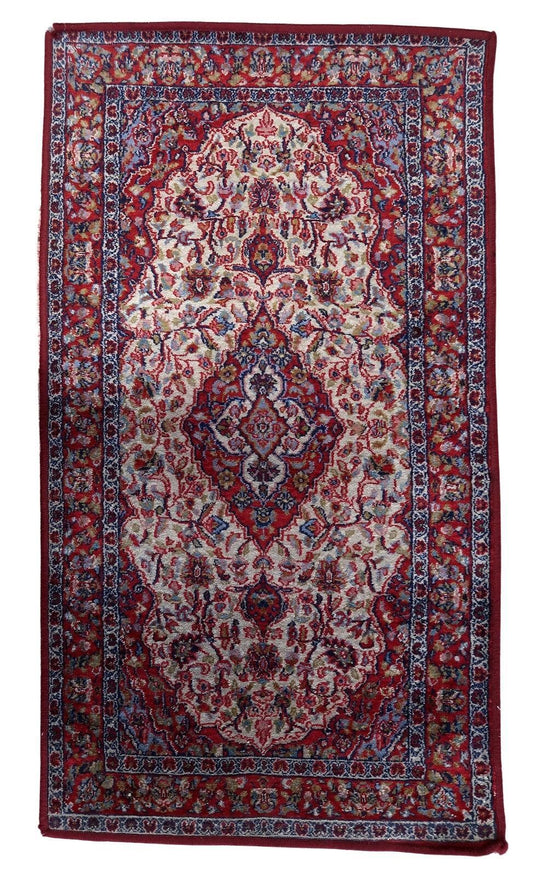 Vintage Indian rug showcasing dominant red hue with intricate geometric motifs and floral elements