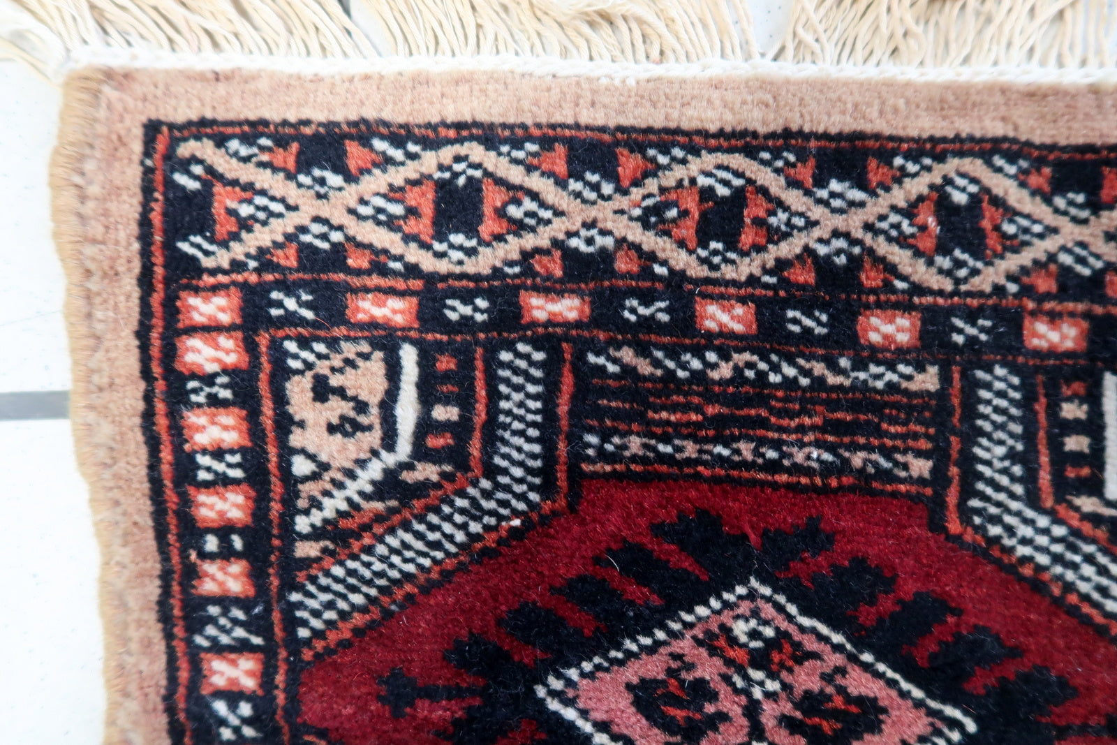 Close-up of the geometric and symmetrical motifs woven into the fabric of the mat rug