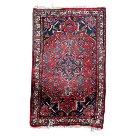 Handmade Vintage Persian Bidjar Rug - 1960s - Substantial piece with dominant red and navy blue hues, showcasing intricate geometric designs.