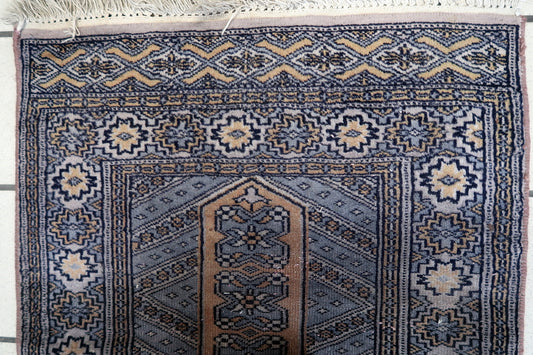 Handmade 1950s Bukhara rug with tribal design


