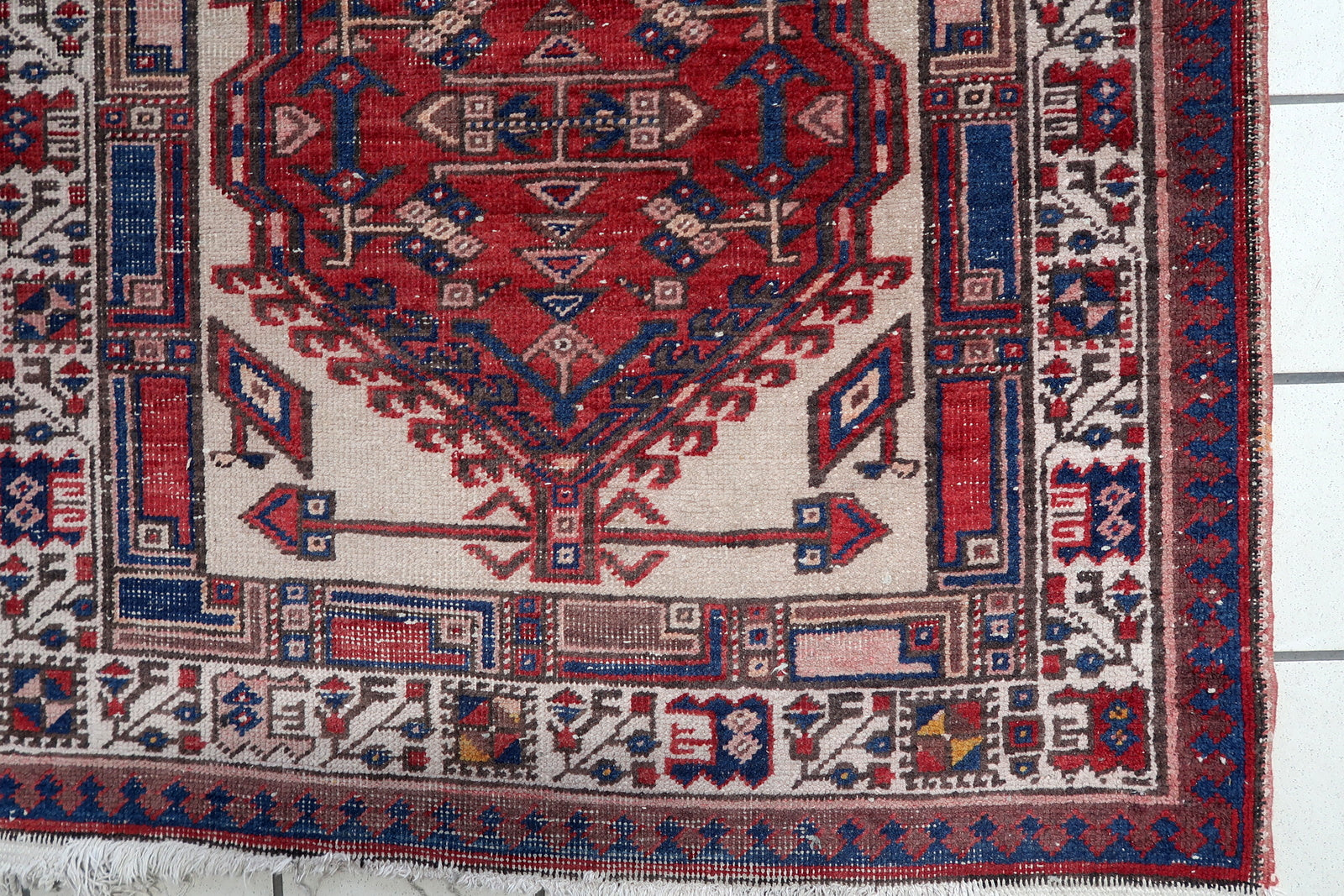Close-up of detailed geometric medallions on a 1920s Persian wool rug
