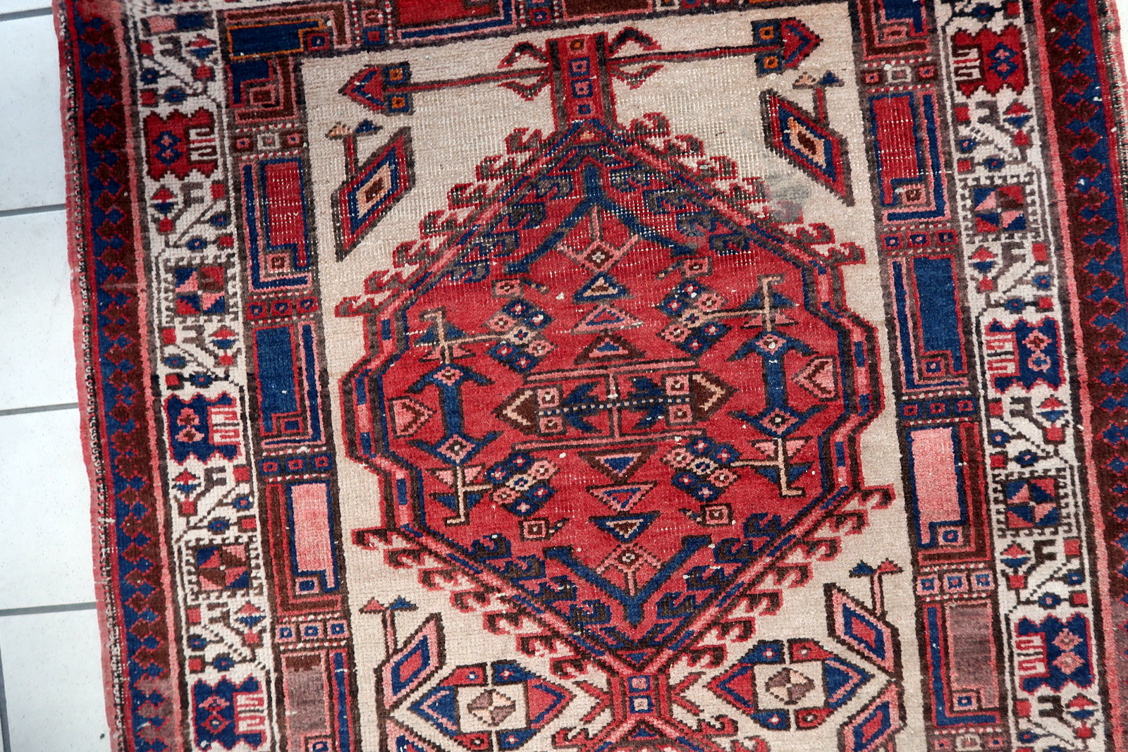 Side view of a vintage Persian wool runner rug with tribal motifs
