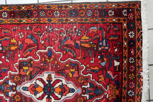 Close-up of detailed geometric medallions on a 1920s Persian wool rug
