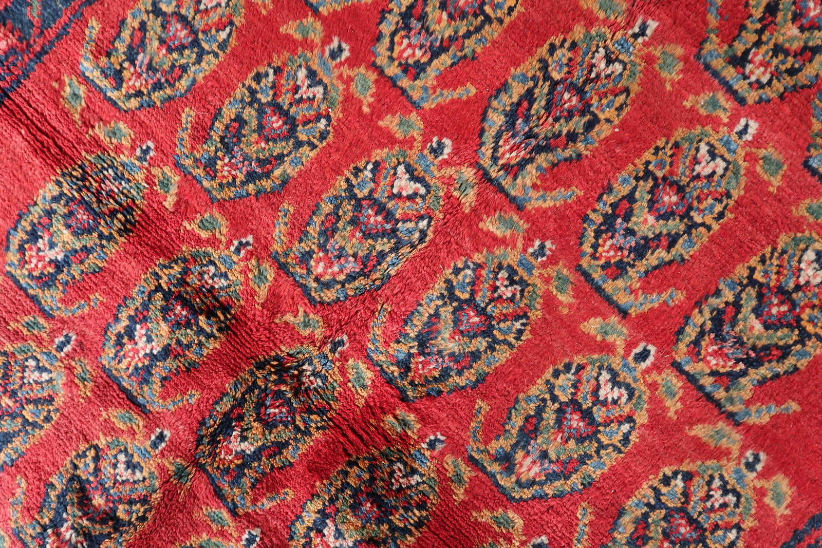 Close-up on the intricate knotting and weaving details of the Persian rug.

