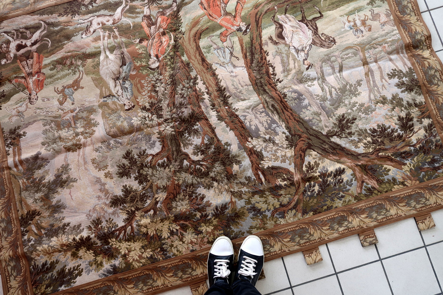 The grand scale of the tapestry displayed on a large wall.

