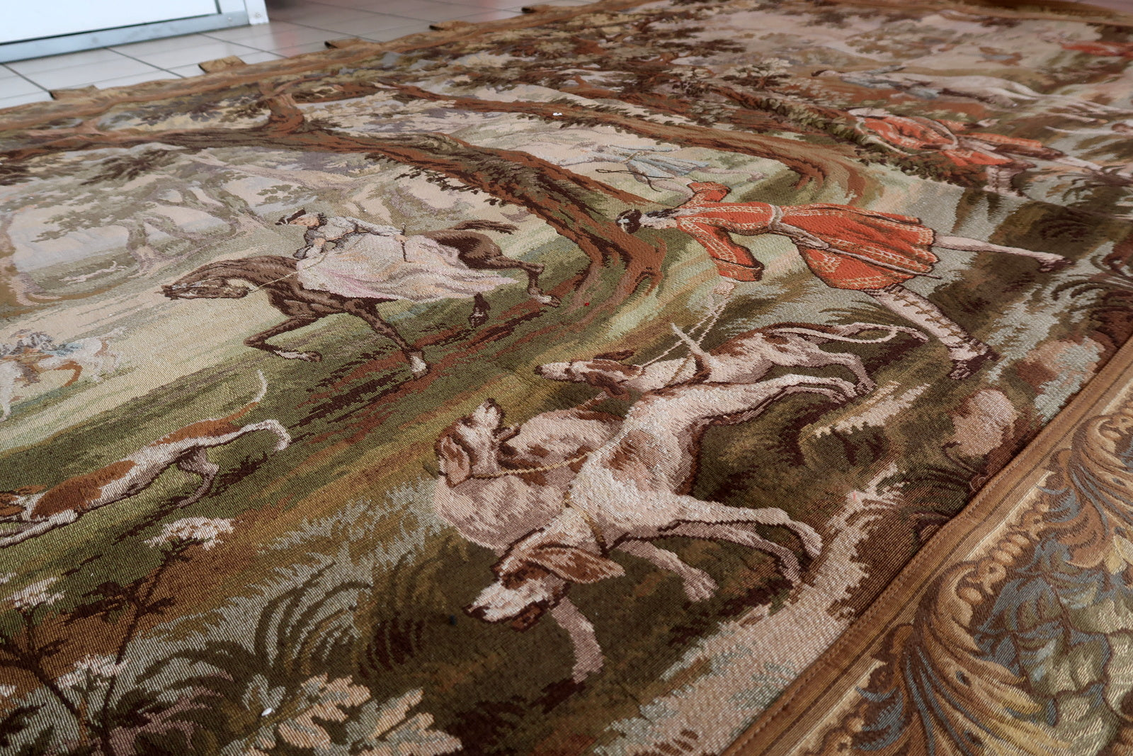 Rich terracotta red accents throughout the woven scene.

