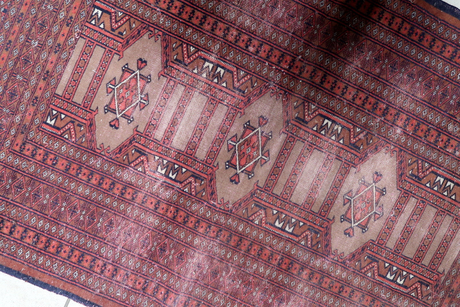 Contrast between the brick red field and navy blue geometric motifs.

