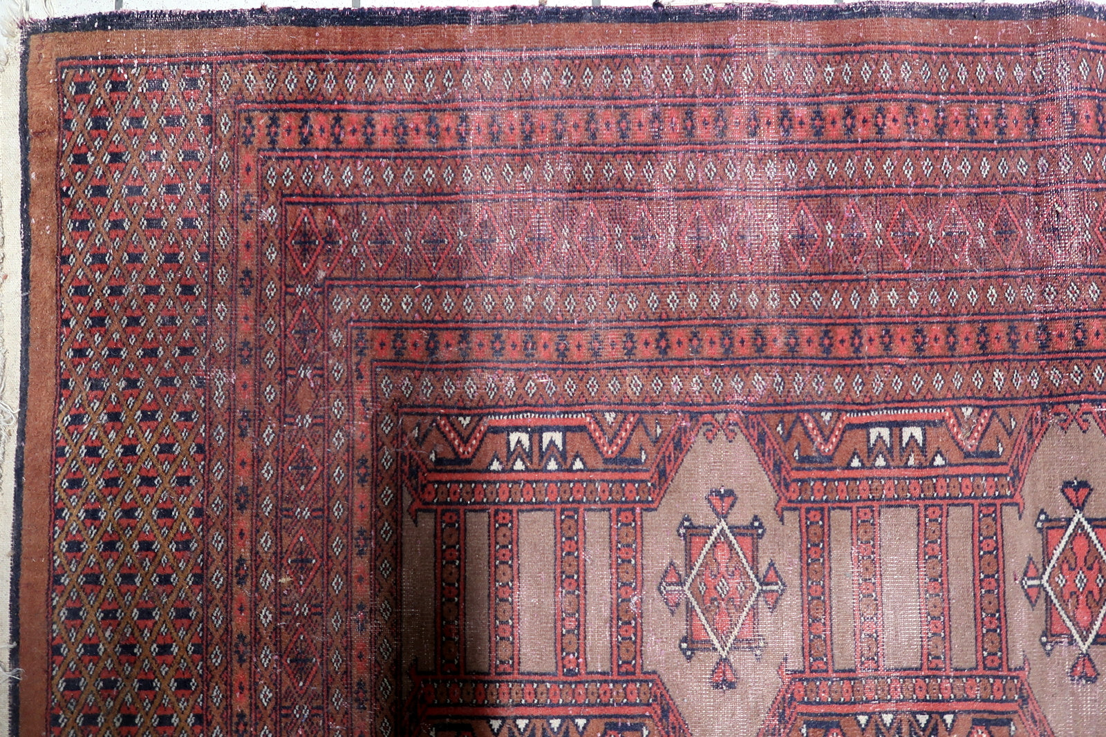 Rich burgundy background color of the vintage Uzbek carpet.


