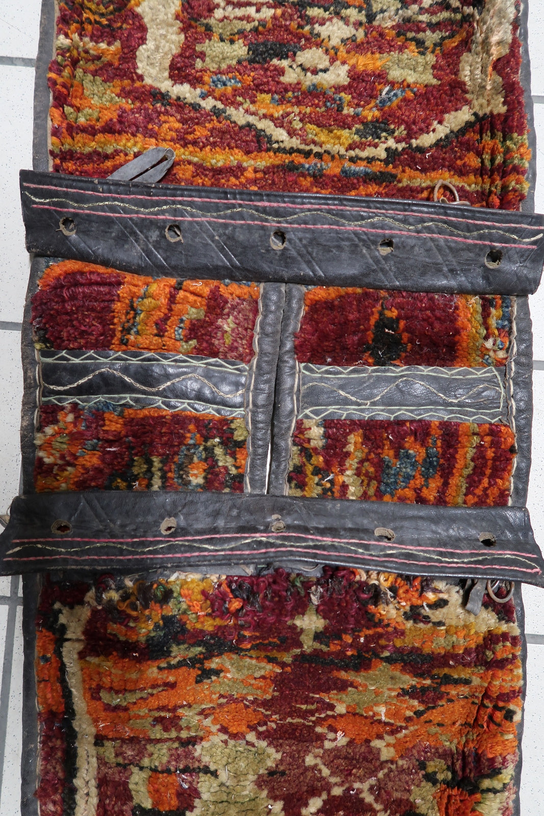 Black leather straps contrasting with colorful wool

