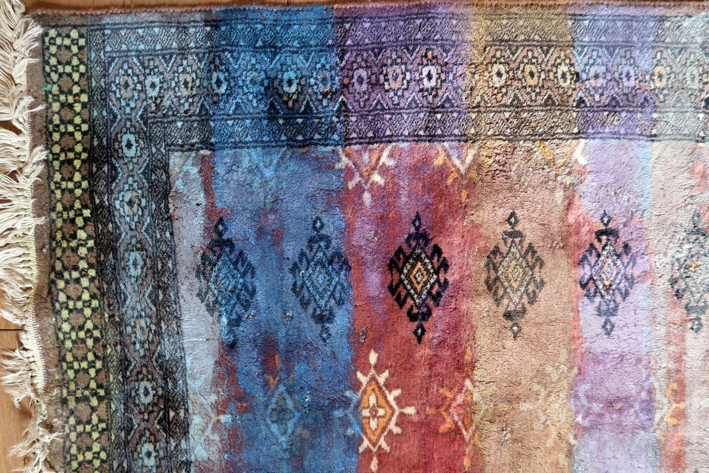 Traditional gul motifs visible beneath blue and purple paint

