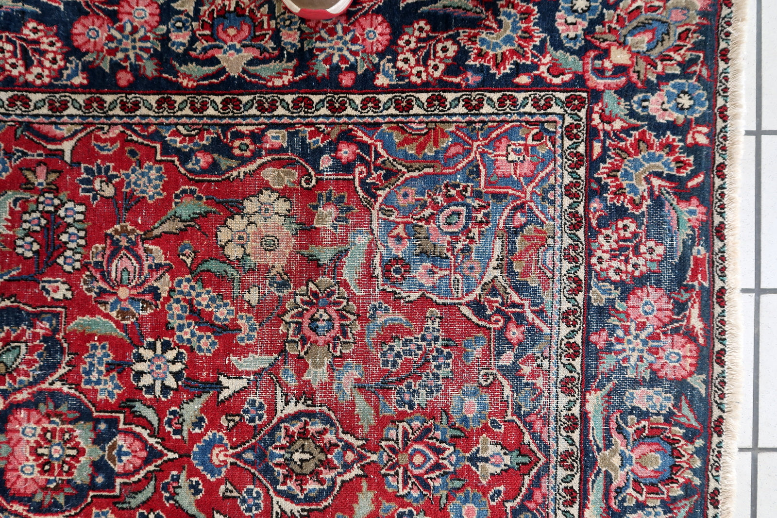 View of the rug's elaborate floral border with complementary motifs.

