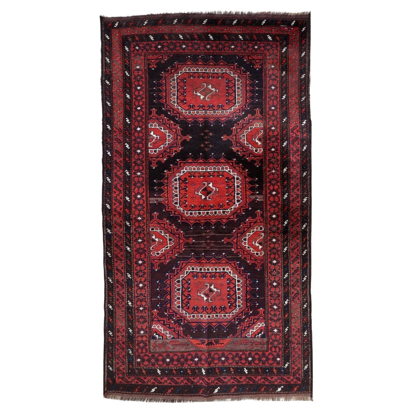 Full top view of the antique Baluch rug showing the complete lattice and geometric pattern.

