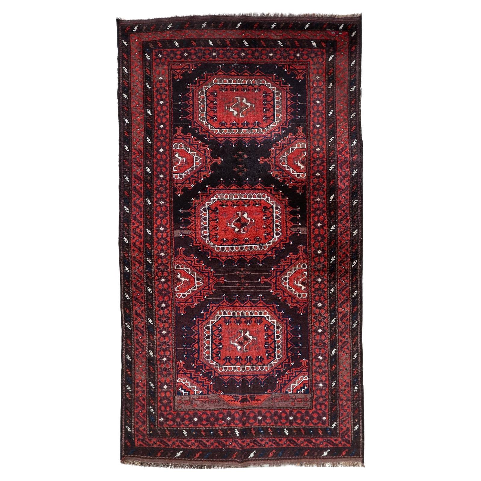 Full top view of the antique Baluch rug showing the complete lattice and geometric pattern.

