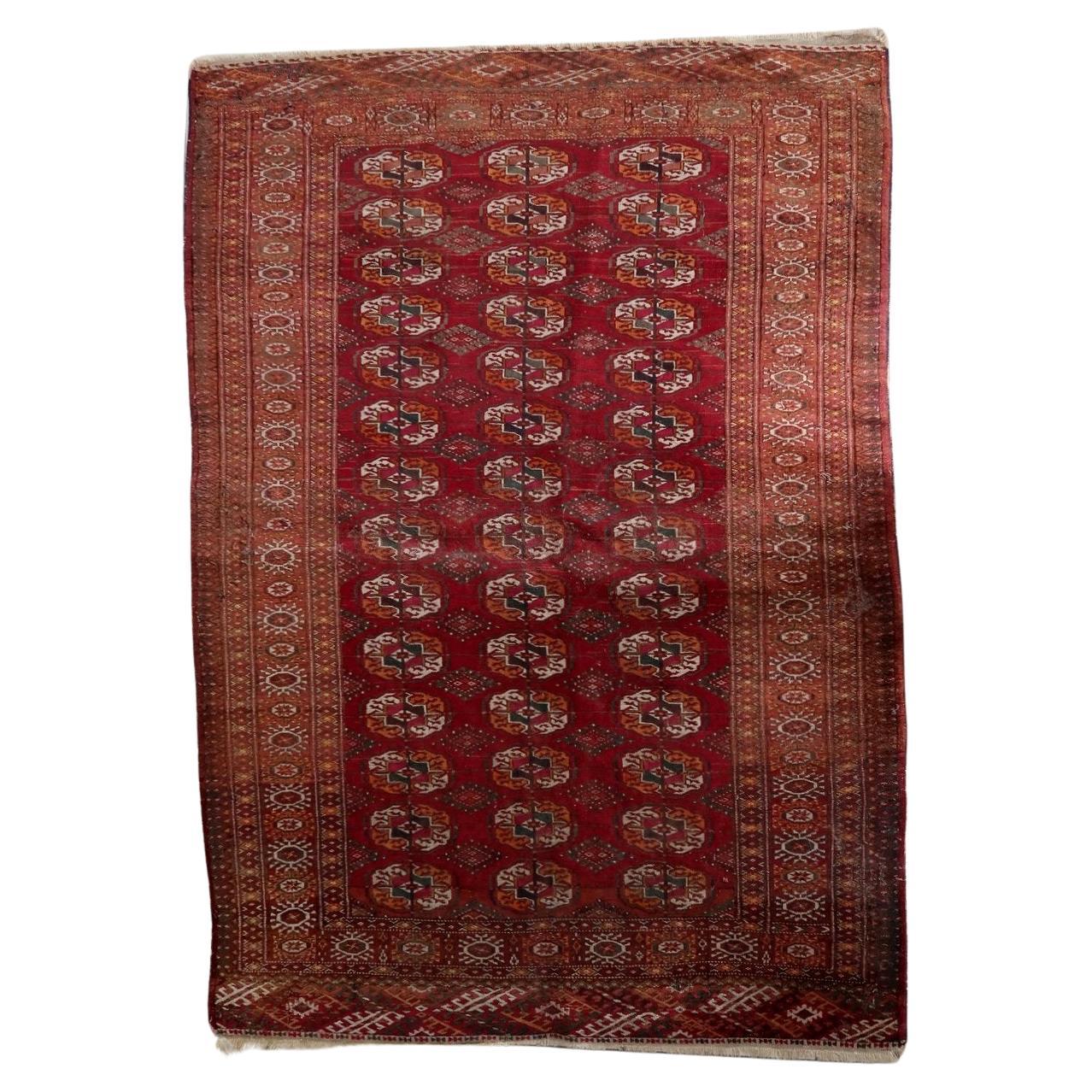 Full top view of the antique Tekke rug showing the rows of iconic gul motifs.

