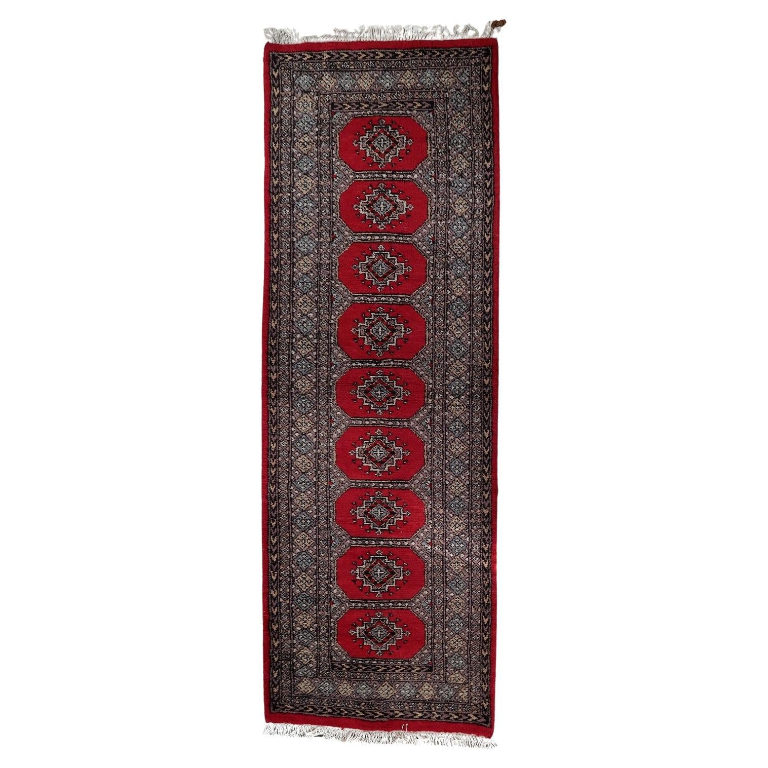 Full top view of the mid-century Uzbek runner showing the rows of graphic gul motifs.


