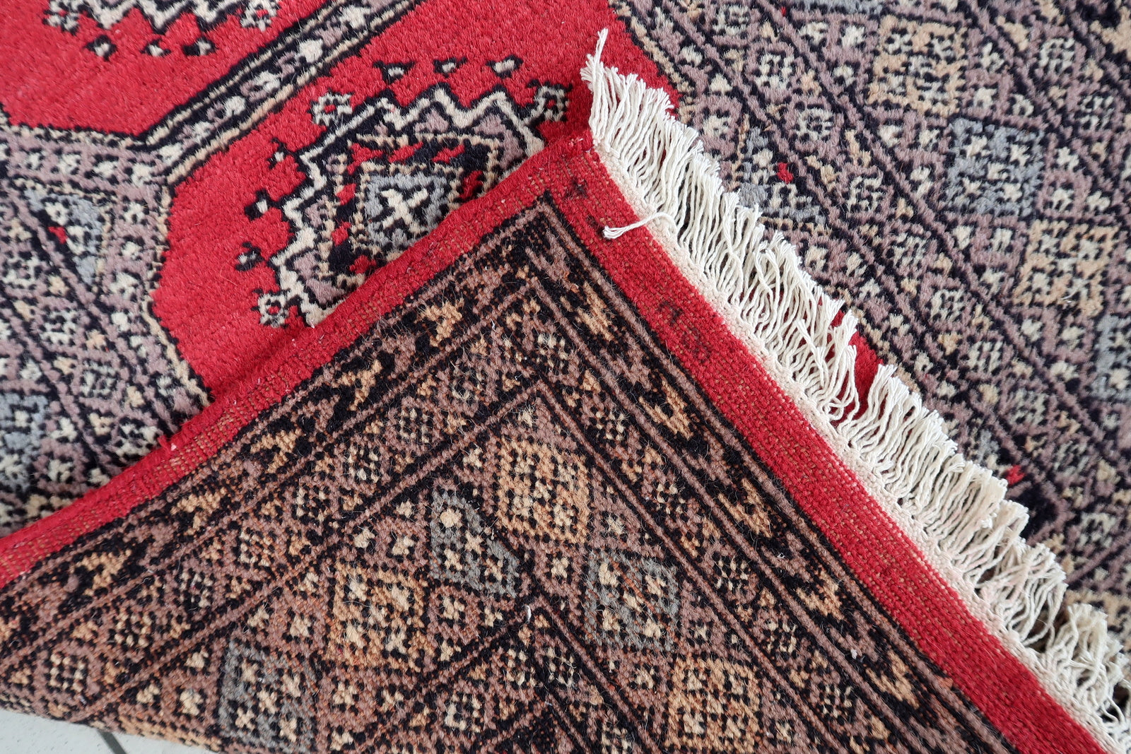 Detail of the runner's end, showing the pattern and fringe termination.

