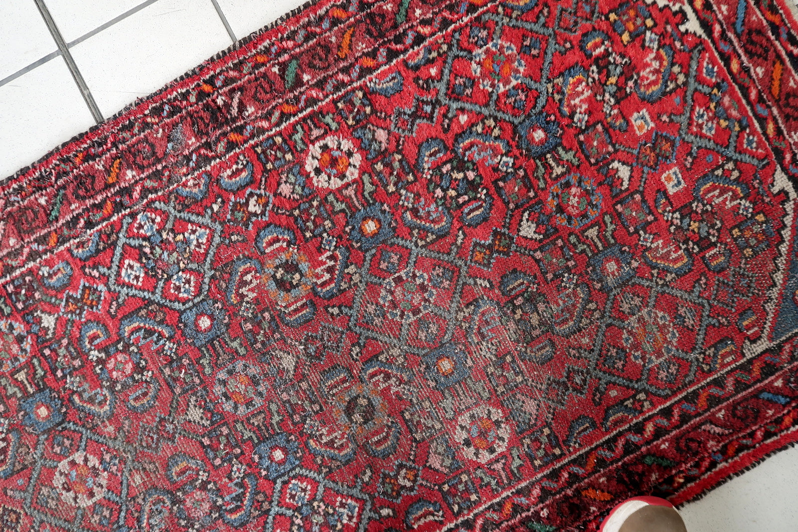 Close-up detail of Persian Hamadan runner geometric design and distressed patina
