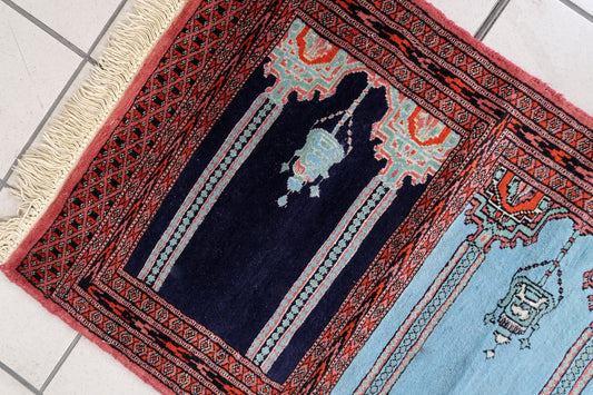 Close-up detail of one arched mihrab niche with a stylized lamp motif.

