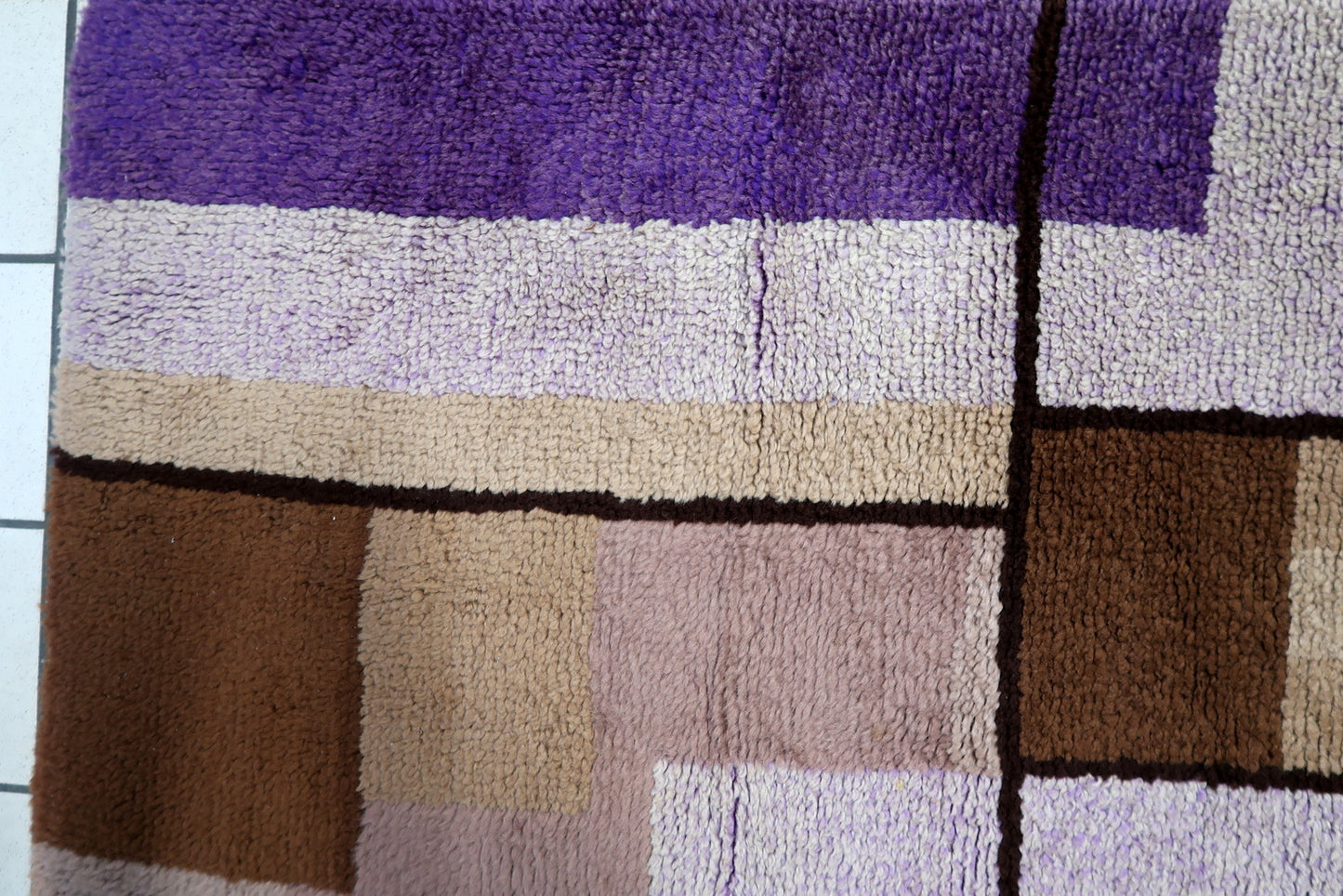 Texture shot highlighting the contrast between the vibrant purples and neutral grounds.

