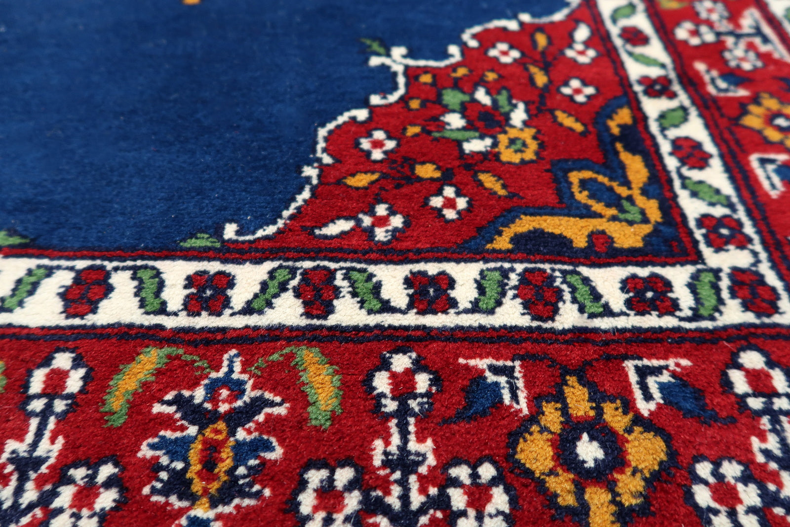 Close-up on the sage green accents nestled among the floral patterns.

