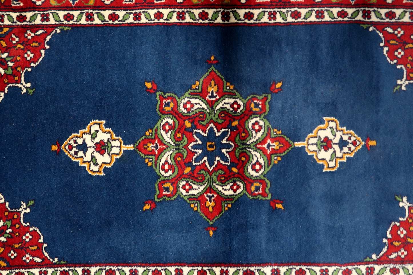 Close-up of a graceful floral spray or vase motif within the design.

