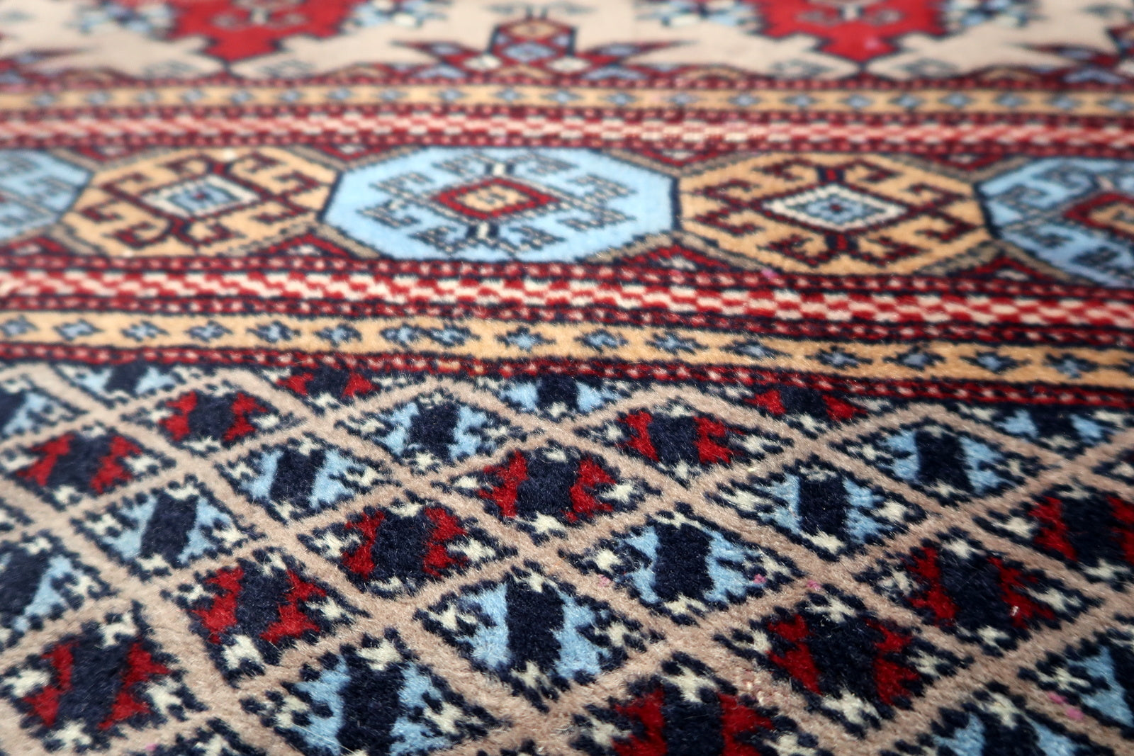 Antique Bukhara floor covering measuring 95 x 124 cm, showcasing traditional weaving techniques and natural dye artistry.

