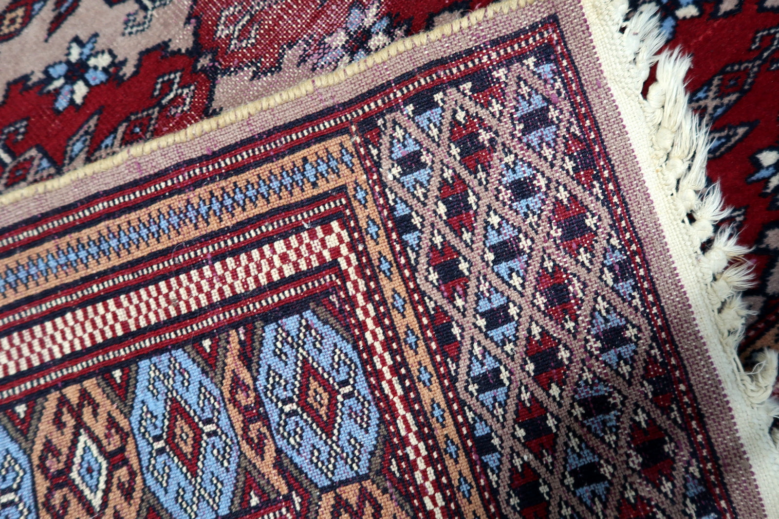 Vintage wool rug with a captivating distressed patina, revealing nearly 100 years of history and nomadic craftsmanship.

