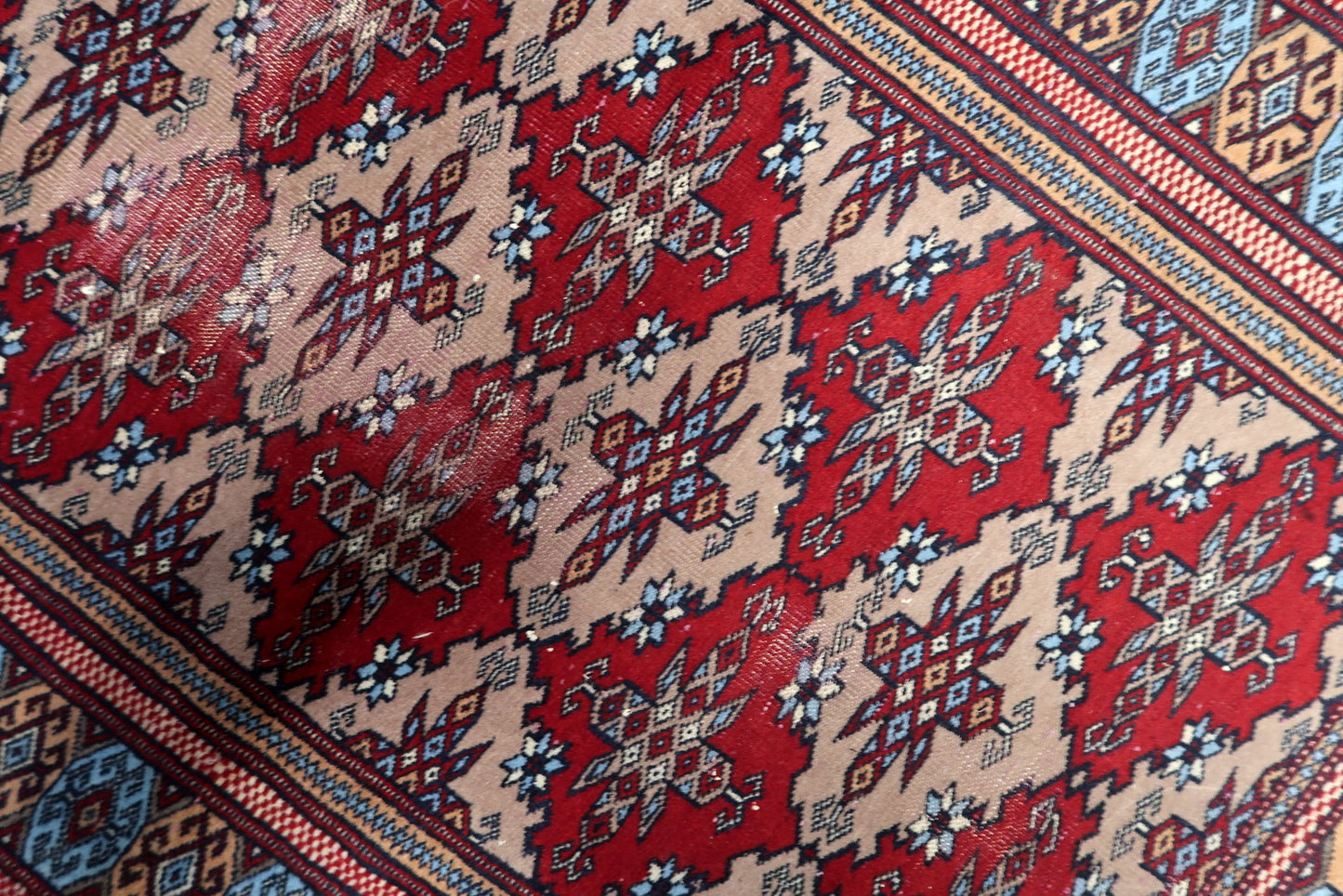 Traditional hand-knotted Bukhara carpet from the 1920s, displaying a century-old patina and authentic wear for collectors.


