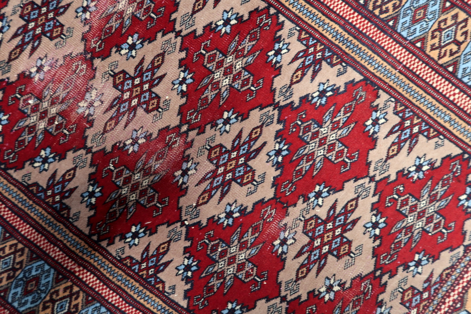 Traditional hand-knotted Bukhara carpet from the 1920s, displaying a century-old patina and authentic wear for collectors.


