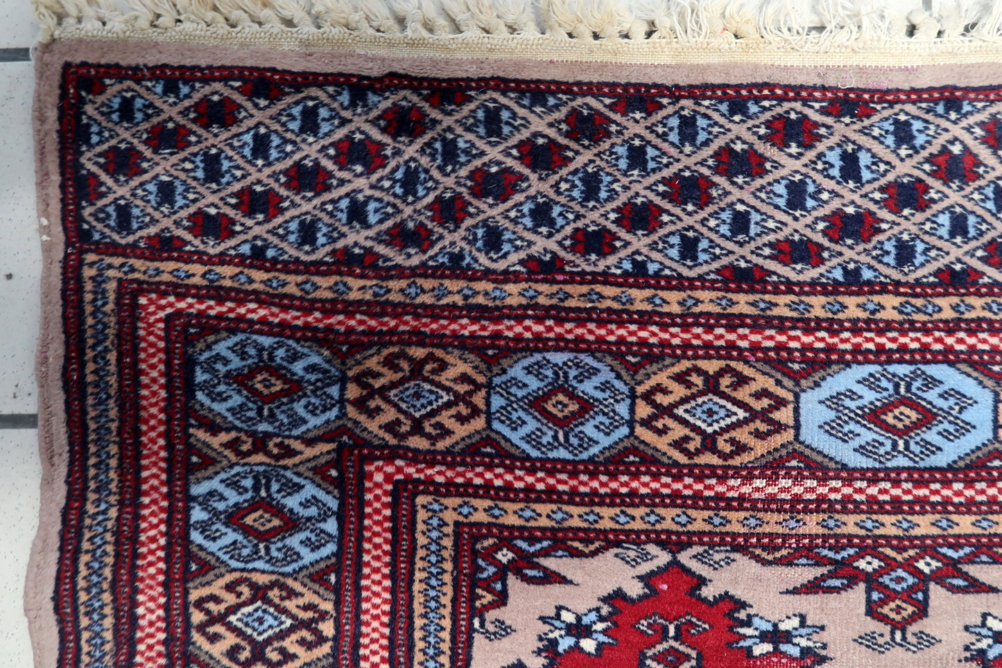 Distressed antique rug in warm earth tones, perfect for use as a wall hanging or light-use decorative accent.

