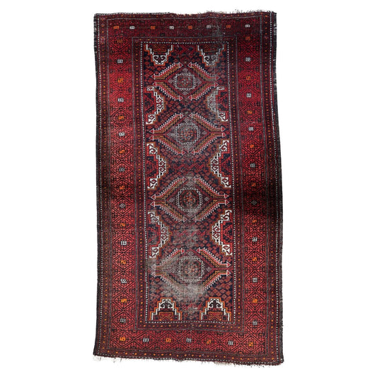 Antique Afghan Baluch rug from the 1920s featuring four large serrated diamond medallions on a deep burgundy field.

