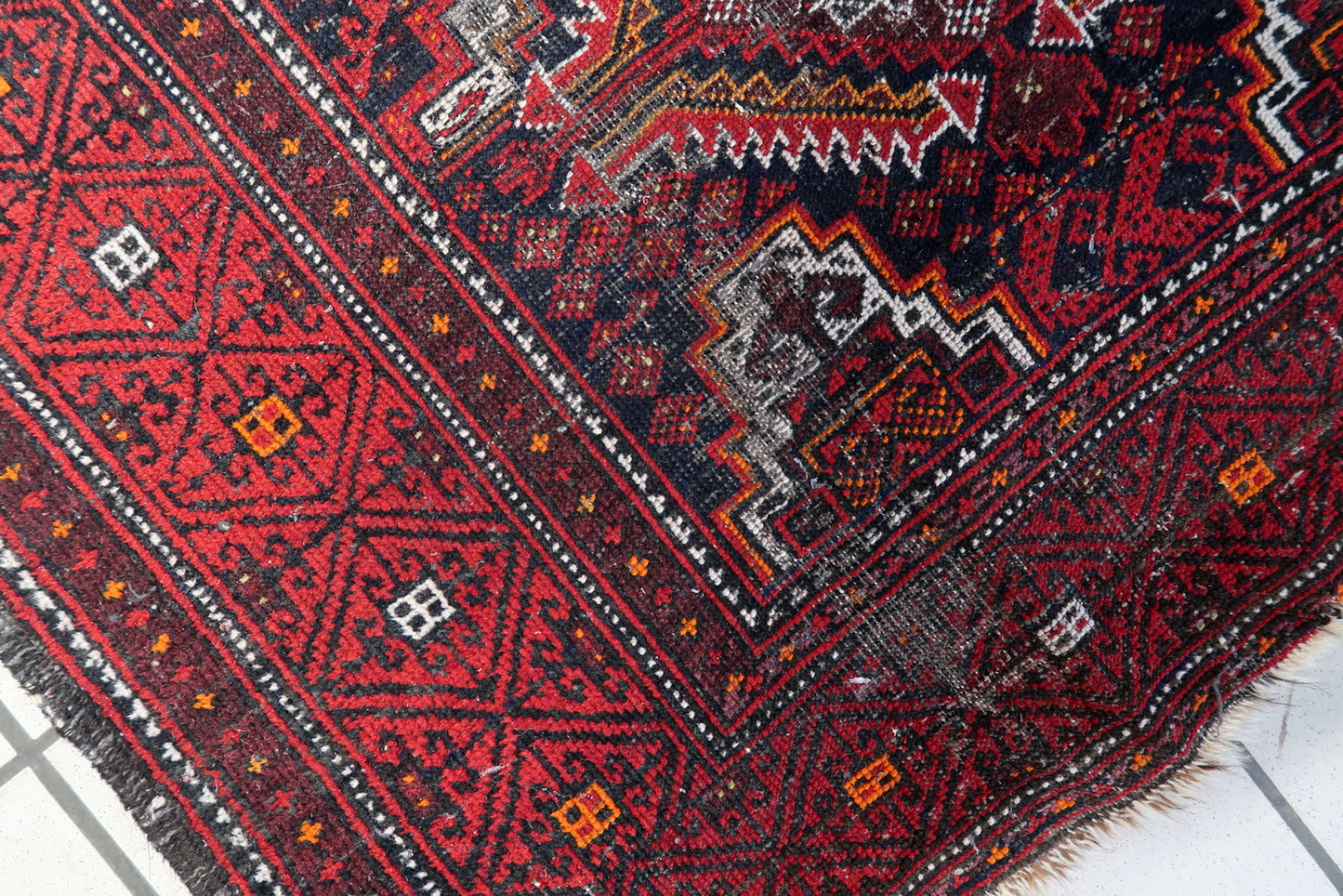 1920s Afghan tribal runner with a sophisticated palette of deep reds, browns, and cream accents.

