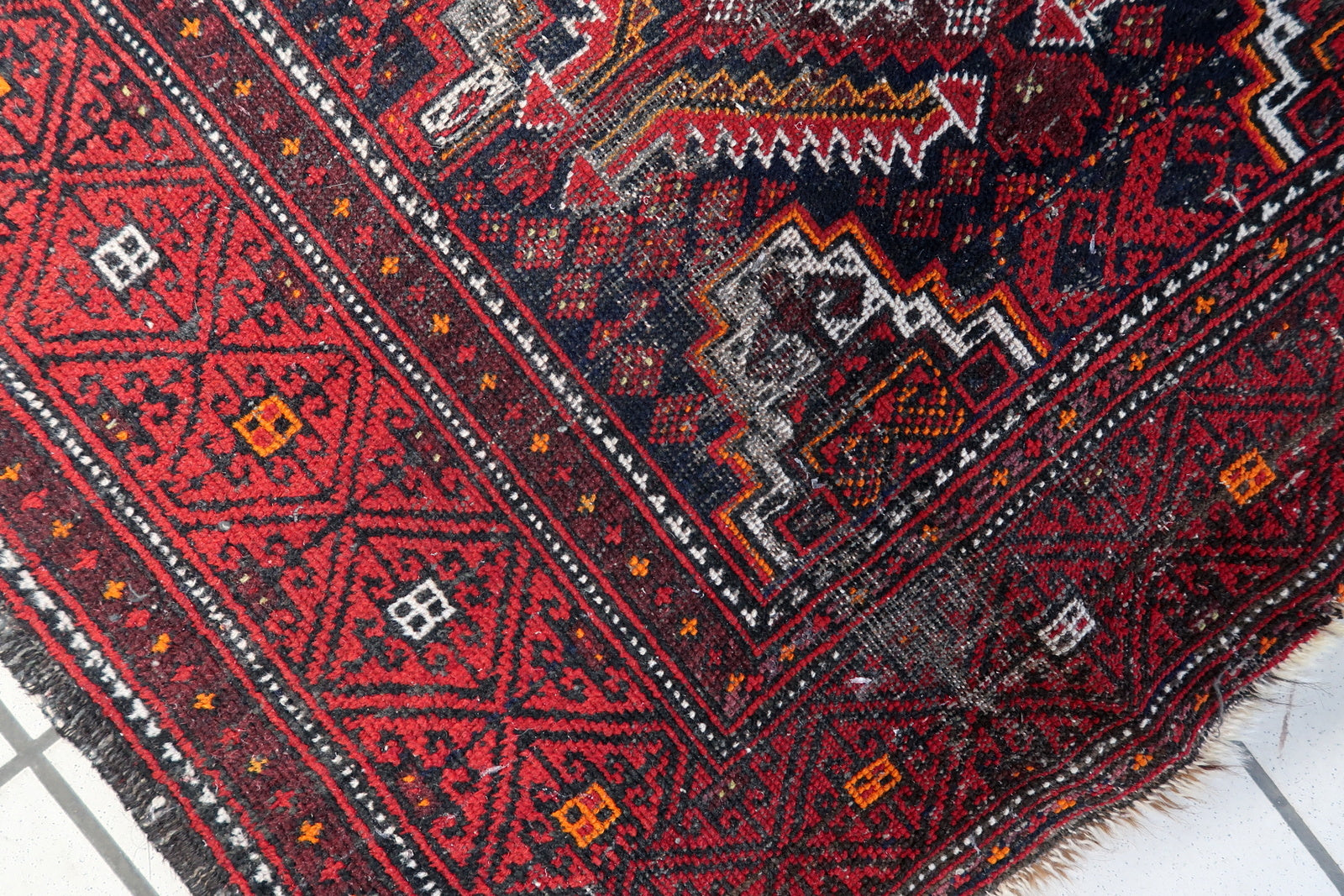 1920s Afghan tribal runner with a sophisticated palette of deep reds, browns, and cream accents.

